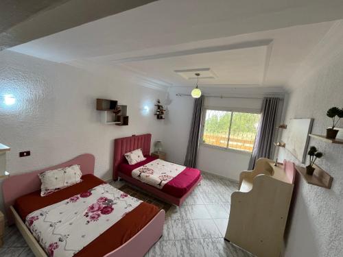 a bedroom with two beds and a window at Dar halouma in Tabarka