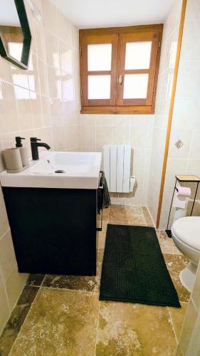a bathroom with a white sink and a toilet at Maison rénovée, centre médiéval de Belvès in Belvès