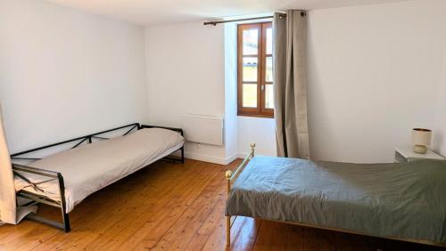 a bedroom with two beds and a window at Maison rénovée, centre médiéval de Belvès in Belvès