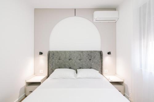 a bedroom with a large white bed and two night stands at Stanovic Bungalow in Ulcinj