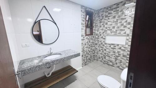 a bathroom with a sink and a mirror at Casa Carol Vans in Peruíbe