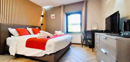 a hotel room with a bed and a television at Durbuy House in Durbuy