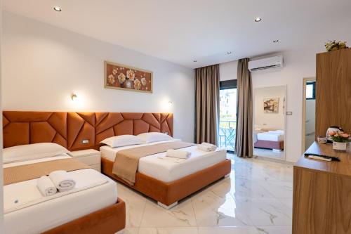 a hotel room with two beds and a television at Hotel Fabio in Ksamil