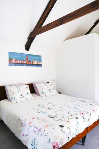 a bedroom with a bed with white sheets at Schuurtje bij de IJssel in Terwolde