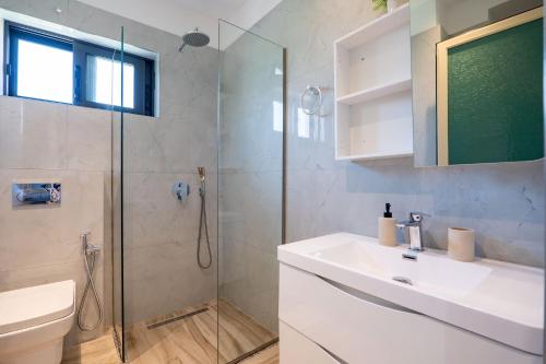 a bathroom with a shower and a sink and a toilet at Hotel Fabio in Ksamil