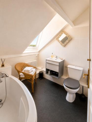 a bathroom with a toilet and a sink and a tub at La Cour Du Puits Chambre Rooibos in Cormeilles
