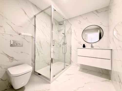 a bathroom with a shower and a toilet and a mirror at Mouzinho Living Centro & Mar in Póvoa de Varzim