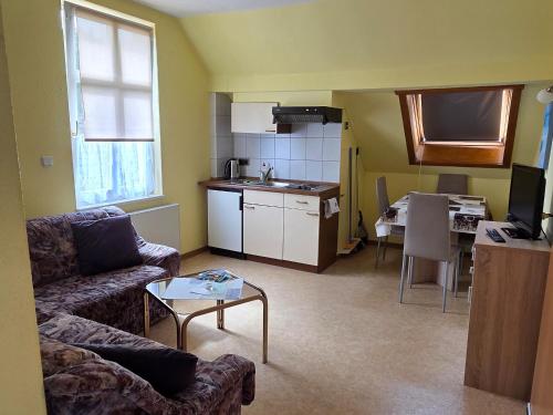 a living room with a couch and a table and a kitchen at Ferienwohnung Stechlin, Neuglobsow in Stechlin