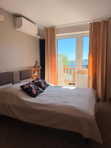 a bedroom with a bed and a large window at Kasztanowe Wrota in Kosewo