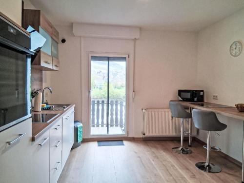 a kitchen with a counter and two stools in front of a window at Holiday Home L by Interhome in Kövenig