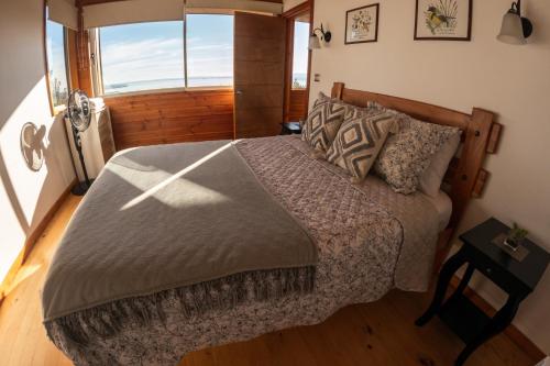 a bedroom with a bed and a large window at Petricor Ecolodge Cab2 in Pucón