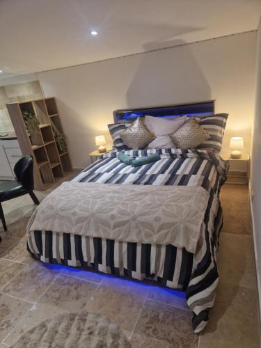 a bedroom with a blue and white bed with pillows at Petit appartement avec jacuzzi in Bédarrides
