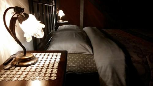 a lamp on a table next to a bed at Affittacamere Cà Marcello in Monselice