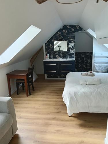 a bedroom with a bed and a desk in a attic at Domaine le bas bois in Neuville-sur-Sarthe