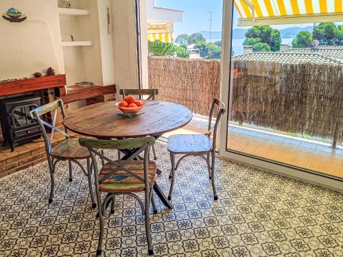 a table with two chairs and a bowl of fruit on it at Apartment Moré III by Interhome in Llança