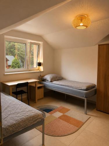 a bedroom with two beds and a desk and a window at Dom Winnica noclegi in Sochaczew