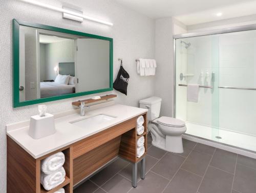 a bathroom with a sink and a toilet and a mirror at Home2 Suites By Hilton Carson City in Carson City