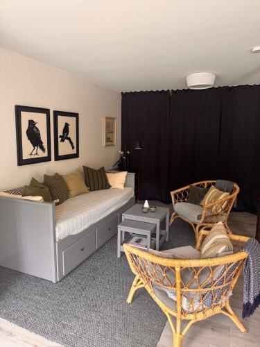 a living room with a bed and a chair at Enkelheten i Kivik in Kivik