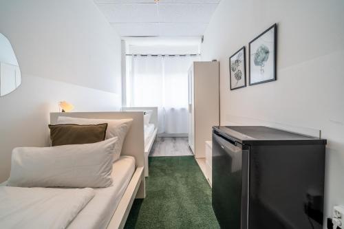 a small room with a couch and a television at D10 I shared bathrooms&kitchen in Garching bei München