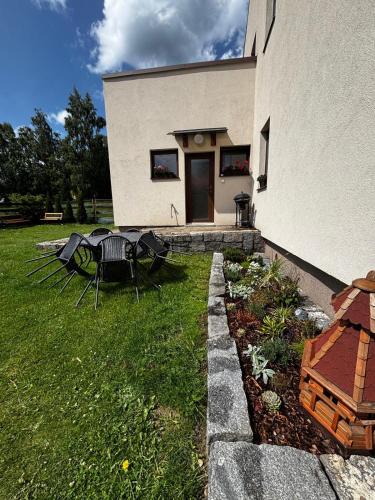 a yard with a table and chairs in front of a building at Apartmán Kocourkov in Jáchymov