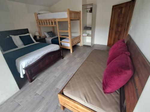 a bedroom with a bed and a couch in it at Roxel Home in Baños