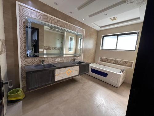 a bathroom with a sink and a tub and a mirror at brick hotel & luxury suites in Lahore