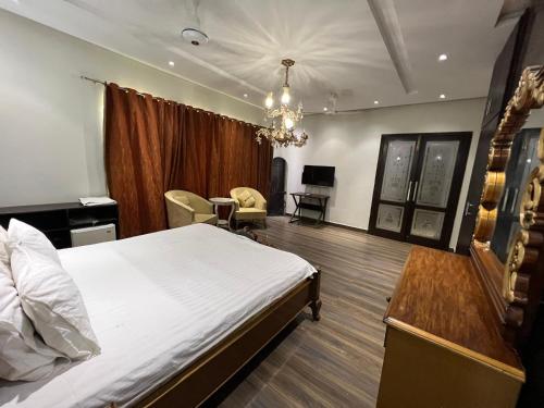 a hotel room with a bed and a table and chairs at brick hotel & luxury suites in Lahore