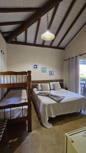 a bedroom with two bunk beds and a chandelier at Pousada Brisa Da Barra in Barra Grande