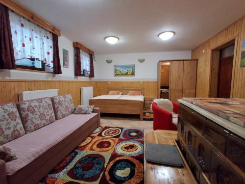 a living room with a couch and a bedroom at Apartment & Studio Forest Paradise in Cerkno