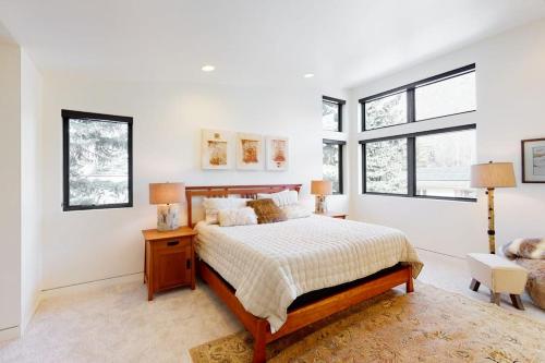 a bedroom with a bed and two windows at Belmont Beauty in Ketchum