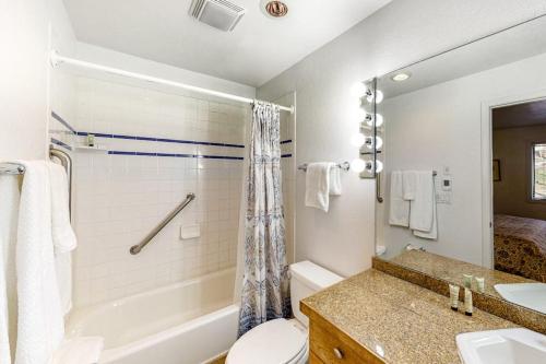 a white bathroom with a tub and a toilet and a sink at Snowmas Village 5AB in Snowmass Village