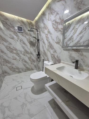 a white bathroom with a toilet and a sink at شاليه روز حتا - Hatta Rose Chalet in Hatta