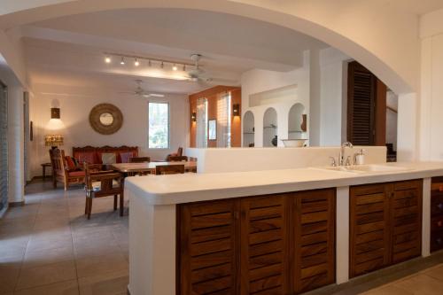 a kitchen with a sink and a living room at Casa Guadalupe - big beach oasis! in Brisas de Zicatela