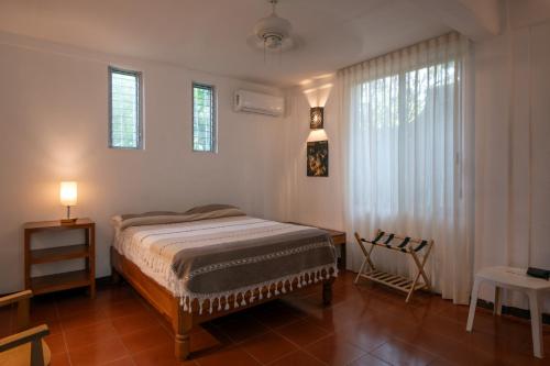 a bedroom with a bed and a window and a table at Casa Guadalupe - big beach oasis! in Brisas de Zicatela