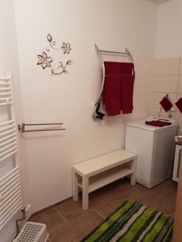 a small bathroom with a washer and dryer and a bench at Ferienwohnung Baatz in Lehnin