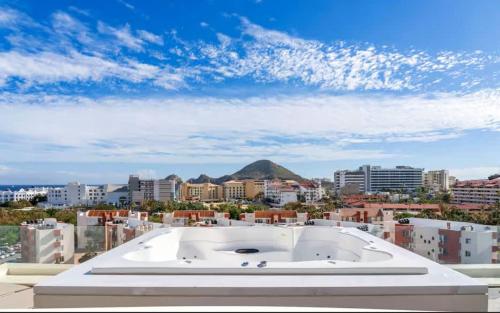 a large white building with a view of a city at 3BR Apartment Beach & Dining Steps Away in Cabo San Lucas