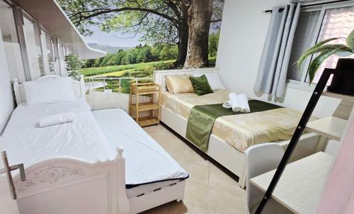 a small room with two beds and a window at BLAGO home Los Angeles 3 in Eilat
