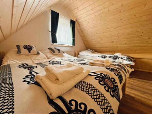 a bedroom with two beds with towels on them at Apartamenty 242E in Chochołów