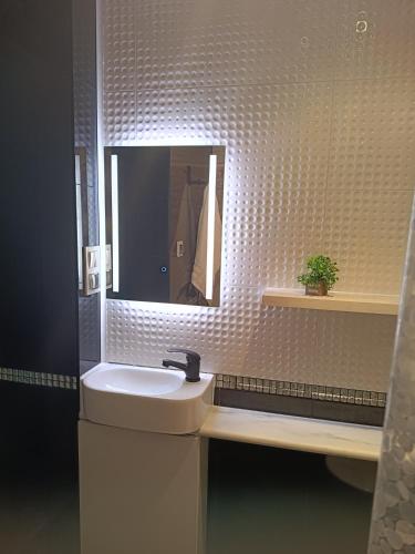 a bathroom with a sink and a mirror at Azyl in Darłówko