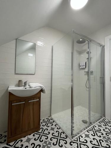 a bathroom with a glass shower and a sink at Leac na Cille in Dingle
