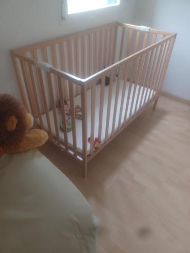 a crib with toys in it with a teddy bear at les Arômes in Locronan