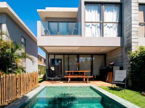 a house with a swimming pool in front of a house at Oka Milagres Beachfront Condominium By MME in Barra do Camaragibe