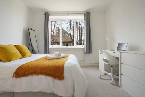 a bedroom with a bed and a desk and a window at Central Sheffield stylish stay in Sheffield