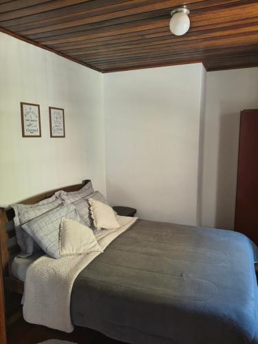 a bedroom with a large bed in a room at Refúgio da Serra - com lareira - 900m do Capivari in Campos do Jordão