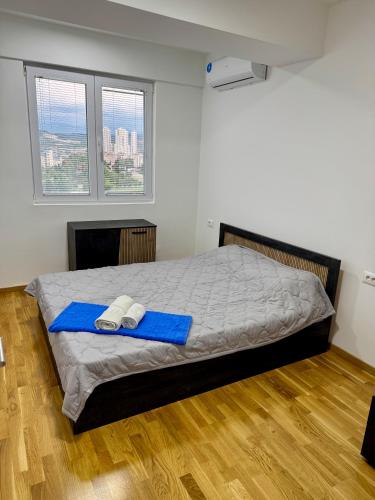 a bedroom with a bed with two towels on it at Skyline Apartment Skopje in Madžari