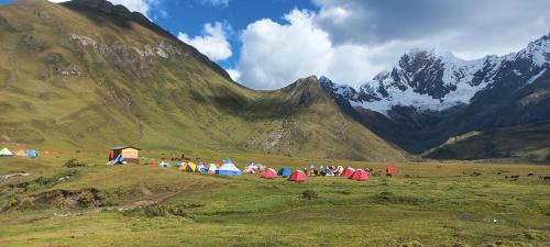 a group of tents on a hill with mountains in the background at Selena Camping in Tayapampa