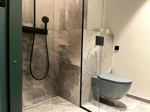 a bathroom with a toilet and a glass shower at Oru Park & Sea Apartment in Tallinn