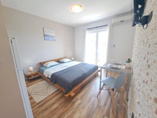 a bedroom with a bed and a desk and a window at Olivus 3 in Miletići