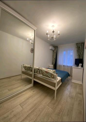 a bedroom with a large mirror and a blue bed at Центр Пассаж ЦУМ in Dnipro