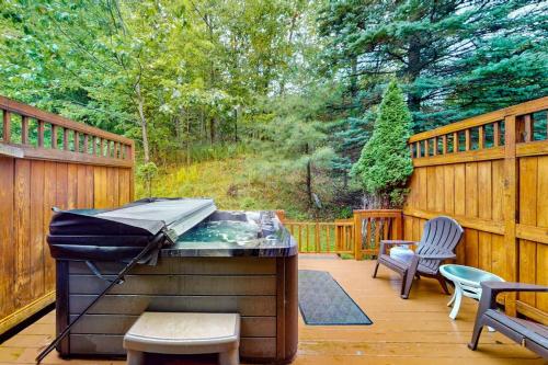 a barbecue on a deck with two chairs and a fence at Stella's Retreat in McHenry
